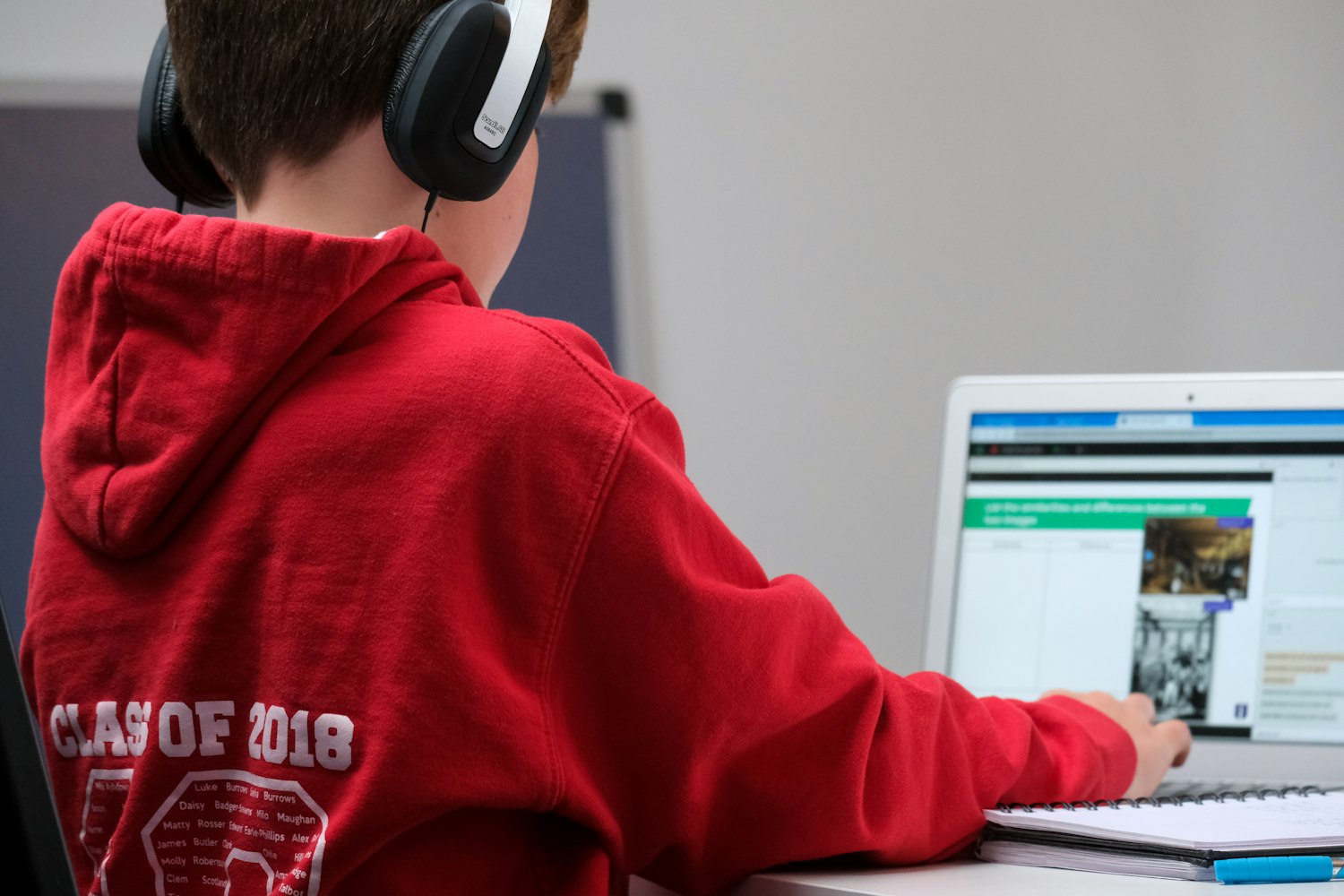 Adolescente concentrado escribiendo código en su computador portátil